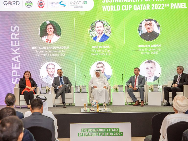 The GORD Advisory team on stage with Dr. Talar Sahsuvargolu during a Qatar 2022 sustainability event, highlighting collaborative efforts.